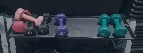 ジムの棚に置かれたダンベルとケトルベル